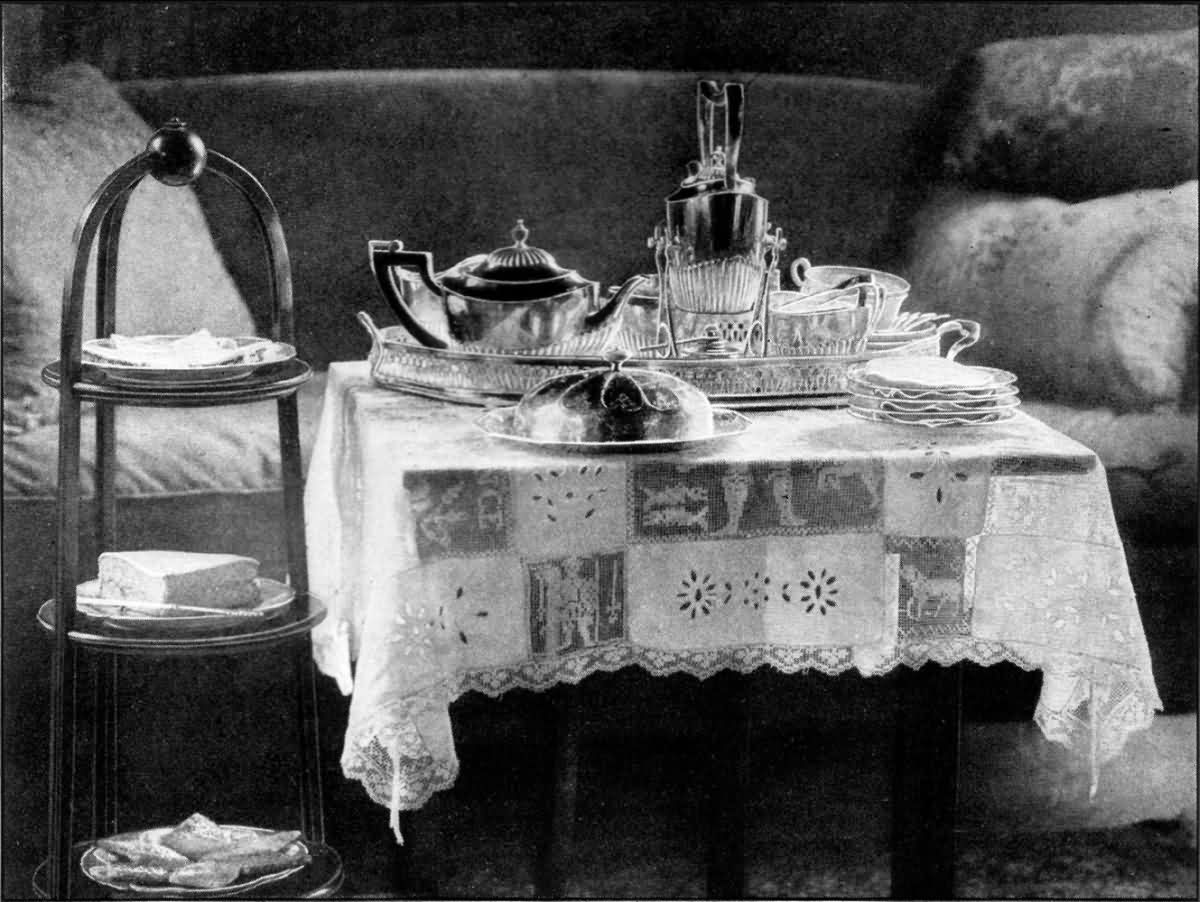 Vintage silver tea service with sandwiches and cakes