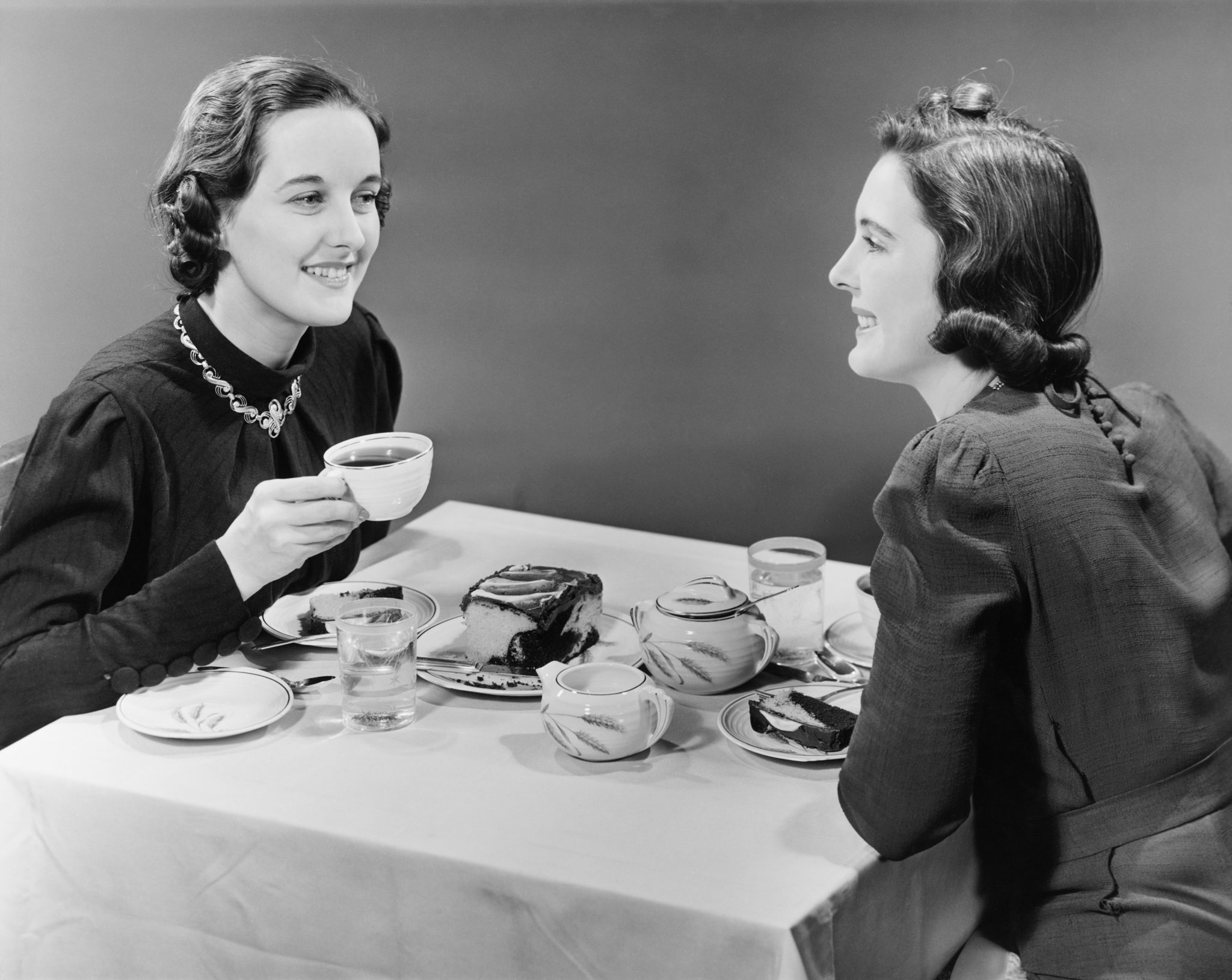 A vintage afternoon tea table with teapot, cups and cake