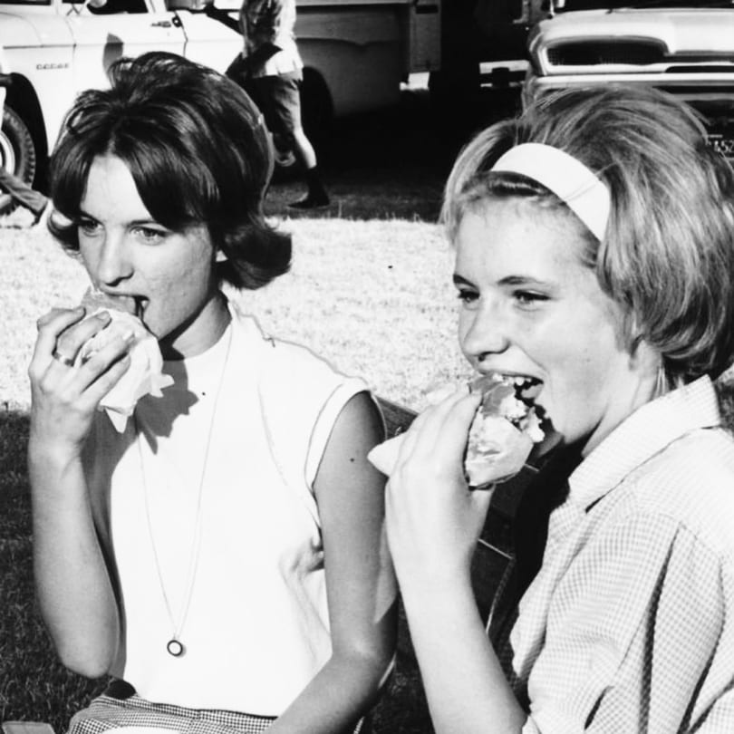 Friends enjoying sandwiches at a vintage picnic lunch