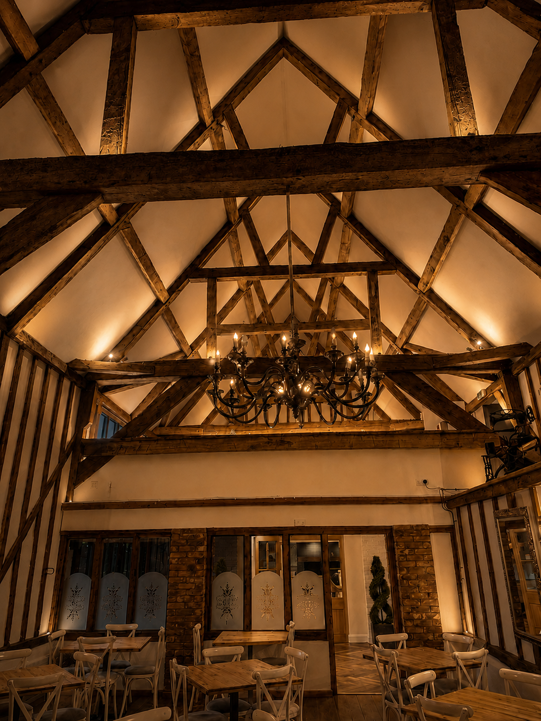 The illuminated oak beams and chandelier inside the Little Barn Restaurant