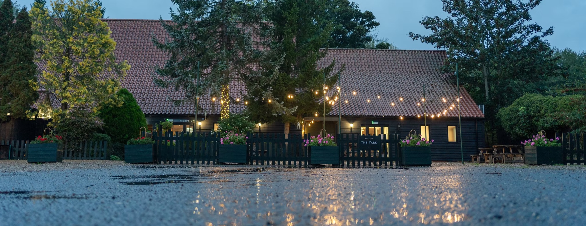 The Little Barn courtyard glowing with festoon lights at night