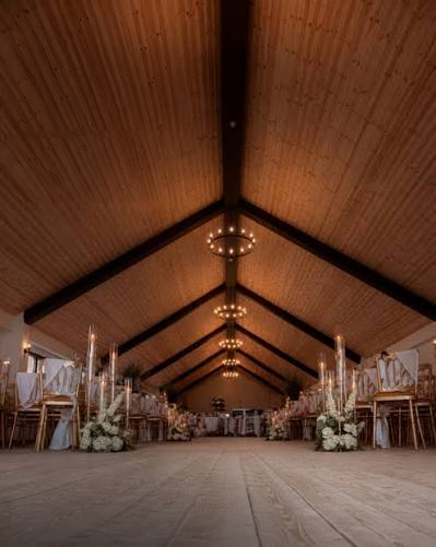 The Mulberry Barn dressed for a wedding beneath its timber ceiling and chandeliers