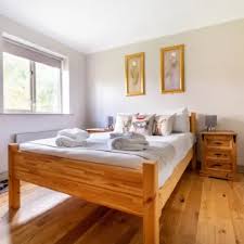 A welcoming Farmhouse bedroom with a wooden bed and countryside styling