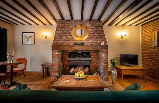 A characterful Farmhouse sitting room with exposed brick fireplace and timber beams